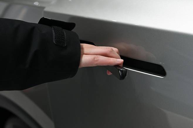 A woman opens the door for a Tesla YL EV at a showroom in Beijing on Feb. 3. [AFP/YONHAP]