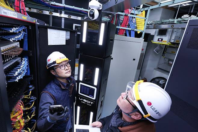 LG유플러스 직원이 AI 자율주행 로봇 ‘유-봇(U-BOT)’을 소개하고 있다. [LG유플러스 제공]