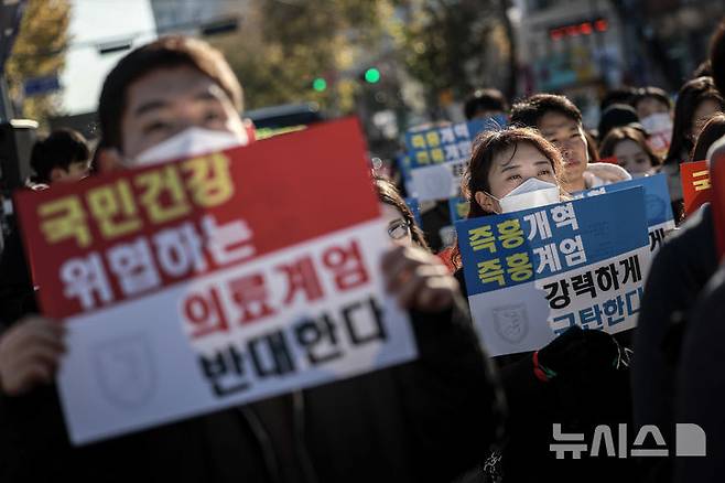 [서울=뉴시스] 정병혁 기자 = 지난 2024년 12월 8일 서울 종로구 대학로에서 열린 서울대병원 전공의협의회 비상대책위원회 ‘젊은 의사 의료계엄 규탄 집회’에서 사직 전공의를 비롯한 젊은 의사들이 피켓을 들고 있다. 2024.12.08. jhope@newsis.com