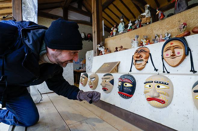 설 연휴를 앞둔 10일 경기 용인시 한국민속촌에서 한 외국인 관광객이 민속탈을 구경하고 있다.