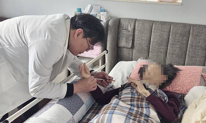 유창훈 횡성군 장기요양 재택의료센터장이 이달 4일 조복덕씨 집에서 조씨 맥박을 측정하고 있다. 횡성=배상철 기자