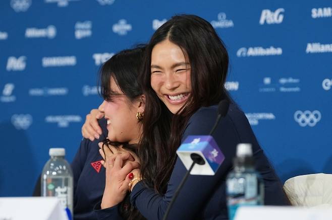 미국 스노보드 국가대표 클로이 김이 9일(한국시간) 이탈리아 리비뇨 스노파크에서 진행한 2026 밀라노·코르티나담페초 동계올림픽 하프파이프 예선 전 기자회견에서 동료와 포옹하고 있다. 리비뇨 AP 연합뉴스