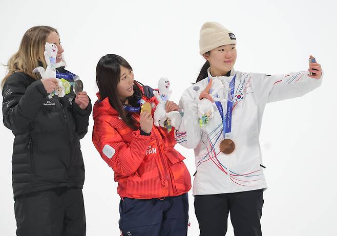 유승은(오른쪽)이 10일 밀라노·코르티나담페초 동계올림픽 스노보드 여자 빅에어 시상식에서 금메달을 차지한 일본의 무라세 고코모(가운데), 은메달을 차지한 뉴질랜드의 조이 사도스키 시넛과 기념촬영을 하고 있다. 연합뉴스