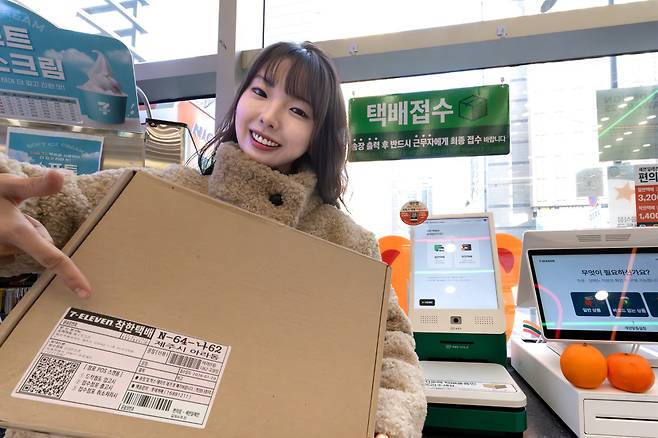 세븐일레븐 직원이 '착한택배' 박스를 들고 서비스를 알리고 있다. [사진=코리아세븐]