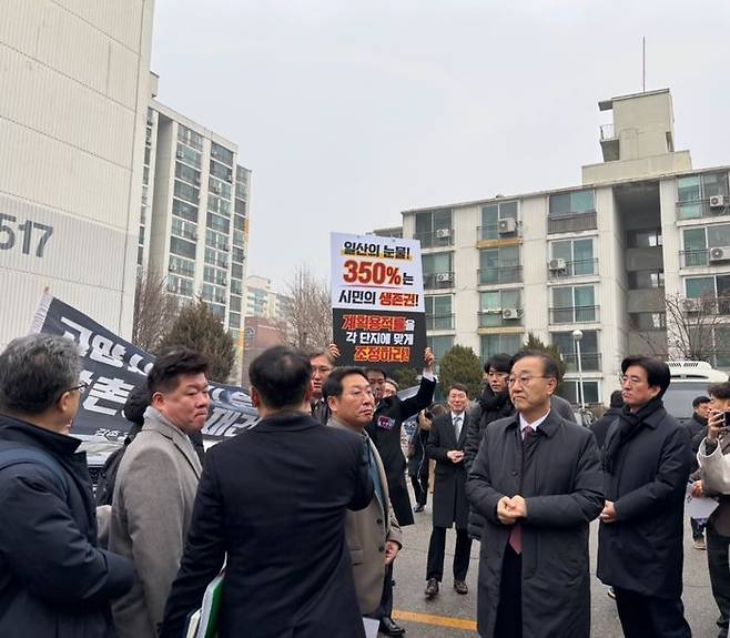 김윤덕 국토교통부 장관(오른쪽)이 11일 경기도 일산 선도지구 중 한 곳인 강촌마을 5단지를 방문하자 지역 주민들이 용적률 상향을 요구하는 피켓과 현수막을 들어보이고 있다.ⓒ데일리안 임정희 기자
