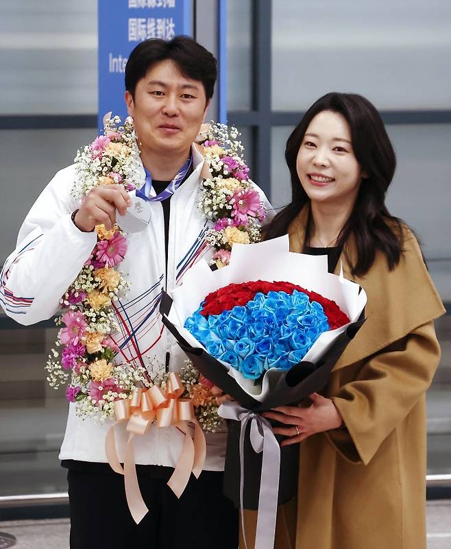 2026 밀라노·코르티나담페초 동계 올림픽에서 한국에 400번째 올림픽 메달을 안겨준 스노보드 김상겸이 10일 오전 인천국제공항을 통해 귀국하며 은메달을 들어보이고 있다. 오른쪽은 아내 박한솔 씨.뉴스1