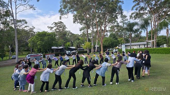 호주 러빙유 캠프 참가자들이 10일(현지시각) 아침 호주 뉴사우스웨일스주 롱포인트콘퍼런스센터에서 서로의 어깨를 주물러주며 체조하고 있다.