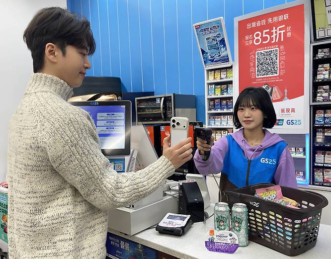 GS25에서 고객이 모바일 기반 간편결제를 이용해 상품을 구입하고 있다.