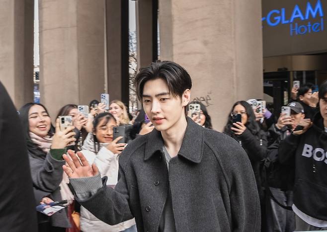 엔하이픈 멤버 성훈이 2026 밀라노·코르티나 동계올림픽 기간 이탈리아 밀라노의 한 호텔을 나서며 팬들에게 인사하고 있다. 뉴욕타임스 캡처