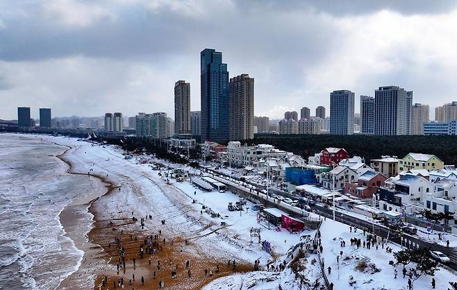 ▲ 눈 내린 해안도로와 바다가 어우러진 중국 산둥성 웨이하이의 겨울 풍경. '눈의 고장'이라 불리는 웨이하이는 겨울마다 이색적인 해안 설경으로 관광객들의 발길을 끈다. /사진제공=웨이하이일보