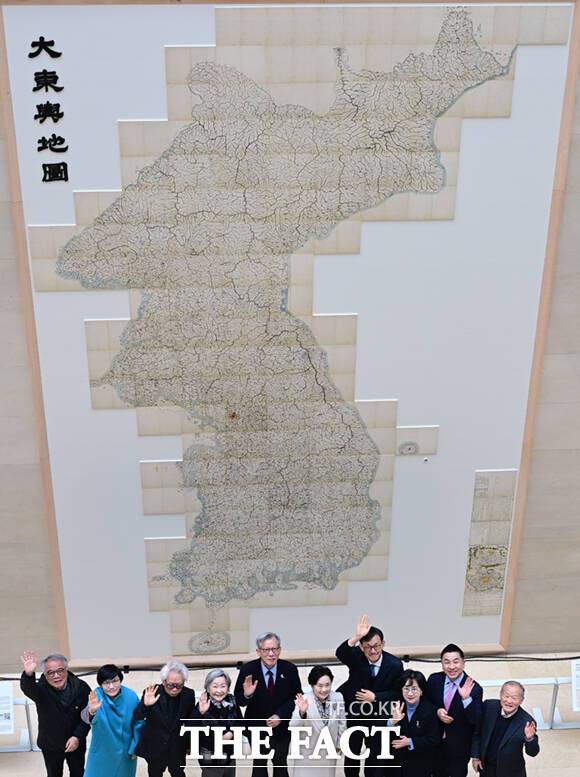 고산자 김정호(1804~1866)의 ‘대동여지도(大東輿地圖)’ 22첩이 12일 서울 용산구 국립중앙박물관 상설전시실 1층 로비 ‘역사의 길’의 벽면에 전시된 가운데, 유홍준 관장을 비롯한 참석자들이 기념촬영을 하고 있다. /이새롬 기자