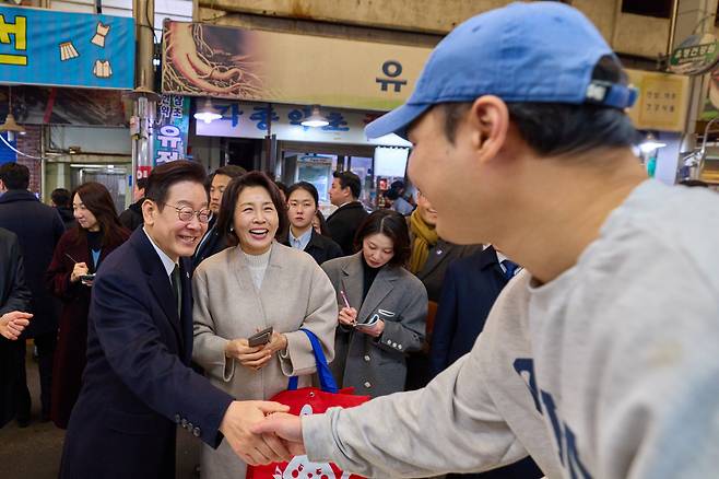 이재명 대통령과 김혜경 여사가 11일 충북 충주시 무학시장을 방문해 시민들과 인사하고 있다. /뉴스1(청와대 제공)