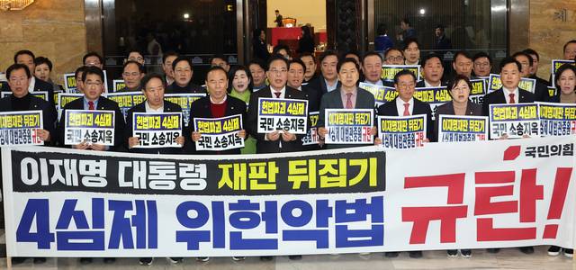 국민의힘 송언석 원내대표 등 의원들이 12일 국회 로텐더홀에서 '4심제 위헌 악법 규탄' 대회를 열고 구호를 외치고 있다. [연합뉴스]