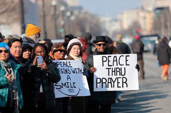 11일(현지시각) 미국 워싱턴 연방 의회 의사당 밖 평화기념비에서 ‘평화를 위한 걷기(Walk for Peace)’ 순례단 도착을 기다리는 시민들. 워싱턴/AFP 연합뉴스