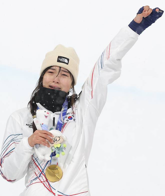 12일(현지시간) 이탈리아 리비뇨 스노파크에서 열린 2026 밀라노·코르티나담페초 동계 올림픽 스키 스노보드 여자 하프파이프 결선에서 90.25점을 획득해 금메달을 획득한 한국 최가온이 시상대에 올라 눈물을 흘리며 팔을 들어보이고 있다. 리비뇨/연합뉴스