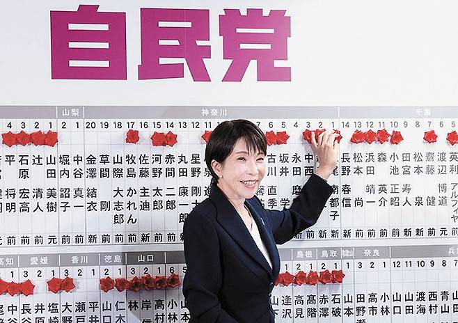 다카이치 사나에 총리가 지난 8일 총선에서 당선된 자민당 후보 이름 위에 장미를 달며 승리를 자축하고 있다. REUTERS=연합뉴스