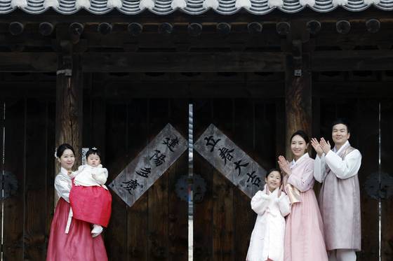 A family poses in front of the Namsangol Hanok Village in Jung District, central Seoul, in celebration of spring on Feb. 4. [NEWS1]