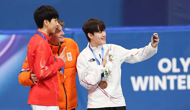 Rim Jong-un, right, who won the bronze medal in the men’s 1,000-meter short-track speed skating event, poses for a photo with gold medalist Jens van ’t Wout of the Netherlands and silver medalist Sun Long of China during the medal ceremony on Feb. 12 at the Milano Ice Skating Arena in Milan at the 2026 Milan-Cortina Winter Olympics. [KIM JONG-HO]