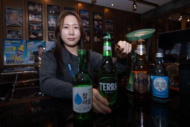 서울 강남구 깐부치킨 삼성점에서 강혜지 하이트진로 주임이 자사 제품인 참이슬, 테라, 켈리, 진로 등을 놓고 포즈를 취하고 있다. 강 주임은 지난해 10월 30일 젠슨 황 엔비디아 CEO, 이재용 삼성전자 회장, 정의선 현대차그룹 회장의 깐부치킨 소맥 회동 때 소맥을 제조해 화제가 됐다. 강예진 기자