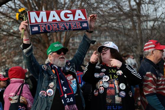 지난달 6일, 미국 워싱턴 D.C.에서 발생한 2021년 1월 6일 미국 국회의사당 공격 5주년을 맞아, 당시 공격 당일 또는 그 여파로 사망한 이들을 추모하기 위해 국회의사당 밖에서 모인 사람들 사이에서 한 남성이 MAGA(미국을 다시 위대하게)를 지지하는 현수막을 들고 있다. 로이터=연합뉴스