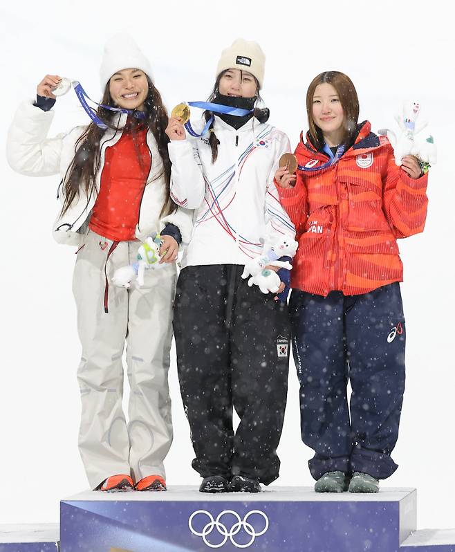 ▲ 한국 여자 스노보드 국가대표 최가온(가운데)이 금메달을 들고 포즈를 취하고 있다. 왼쪽은 은메달을 획득한 미국의 클로이 킴, 오른쪽은 동메달을 따낸 일본의 오노 미쓰키. ⓒ연합뉴스