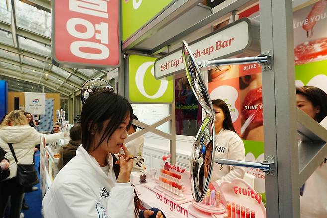 스노보드 하프파이프 금메달 최가온이 밀라노 코리아하우스 ‘올리브영’ 부스에서 립 제품을 테스트하고 있다.(사진제공=CJ그룹)