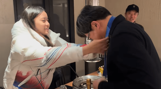 올림픽 설상 종목에서 한국 선수 최초로 챔피언에 오른 17세 3개월 최가온이 자신의 금메달을 구동회 대표에게 걸어주고 있다.&nbsp;