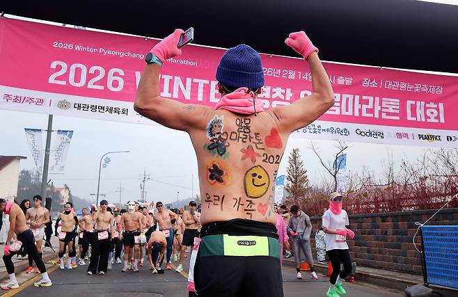 A participant poses for a photo during the Pyeongchang Daegwallyeong Naked Marathon, held in Pyeonchang, Gangwon Province, on Saturday. His body is painted with support messages from his family. (Newsis)