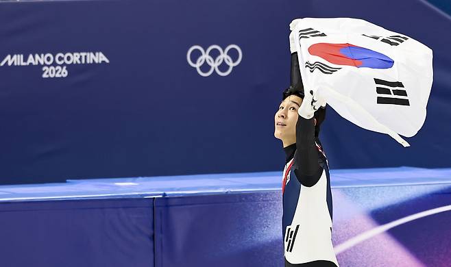 쇼트트랙 황대헌이 14일(현지 시간) 이탈리아 밀라노 아이스 스케이팅 아레나에서 열린 2026 밀라노·코르티나 담페초 동계올림픽 쇼트트랙 스피드스케이팅 남자 1500m에서 은메달을 차지한 뒤 태극기를 들고 경기장을 돌고 있다. 뉴시스