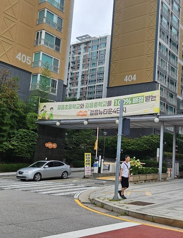 길음뉴타운 4단지 입구에 ‘길음초와 길음중을 100% 배정받는 단지’라는 내용의 현수막이 걸려 있다. 백주연 기자