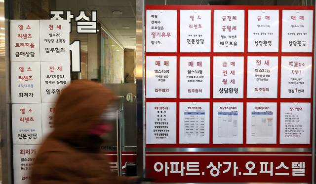 서울 잠실에 위치한 공인중개사 사무실 유리 벽에 부동산 관련 세금과 아파트 매매 물건 등의 안내문이 게시되어 있다. [연합뉴스 제공]