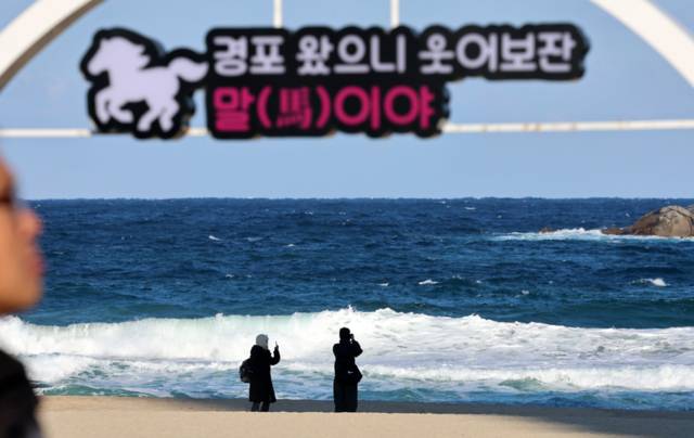 ▲ 강원 강릉시 경포해변을 찾은 관광객들이 강한 바람으로 높은 파도가 이는 추위 속에서 추억을 만들고 있다. 연합뉴스