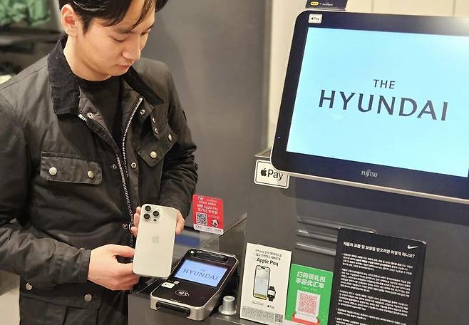 현대백화점 직원이 '애플페이'를 시현하는 모습. [사진=현대백화점]