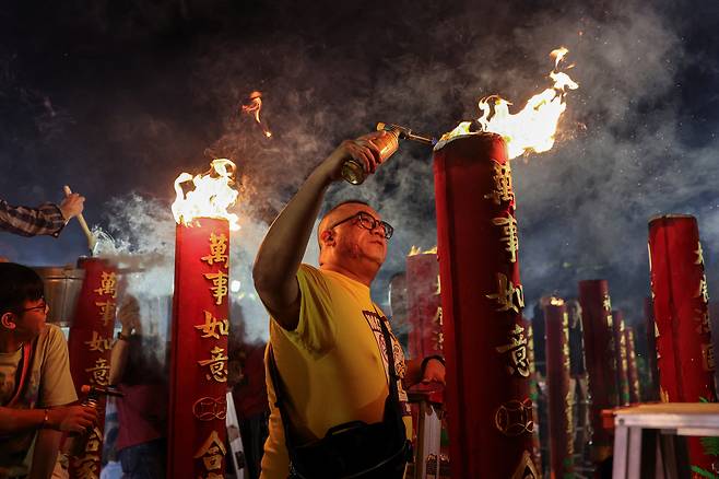 16일(현지시간) 중국 홍콩의 한 사원에서 참배객이 병오년(丙午年) ‘말띠 해’ 설 전야를 맞아 향에 불을 붙이고 있다. 로이터연합