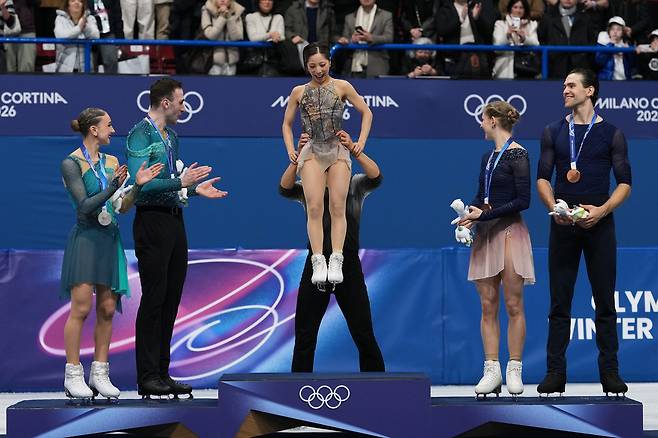 기하라 류이치가 17일 이탈리아 밀라노 아이스 스케이팅 아레나에서 열린 2026 밀라노·코르티나담페초 동계 올림픽 피겨 스케이팅 페어 프리 스케이팅 시상대에서 미우라 리쿠를 번쩍 들어올리며 고마움을 표시하고 있다.  AP연합뉴스