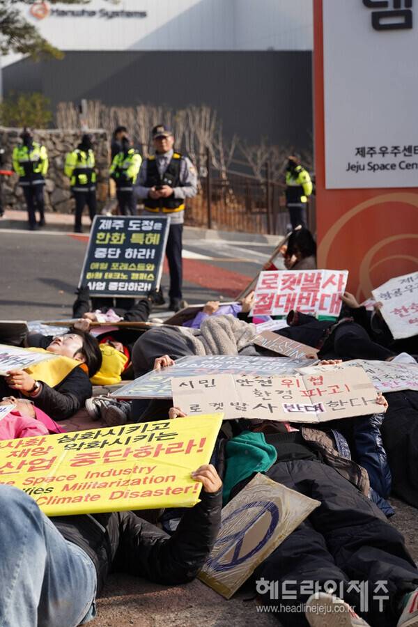 2025년 12월 2일 한화시스템의 제주우주센터 준공식을 규탄하며 die-in 퍼포먼스를 하는 사람들. (사진=또치)