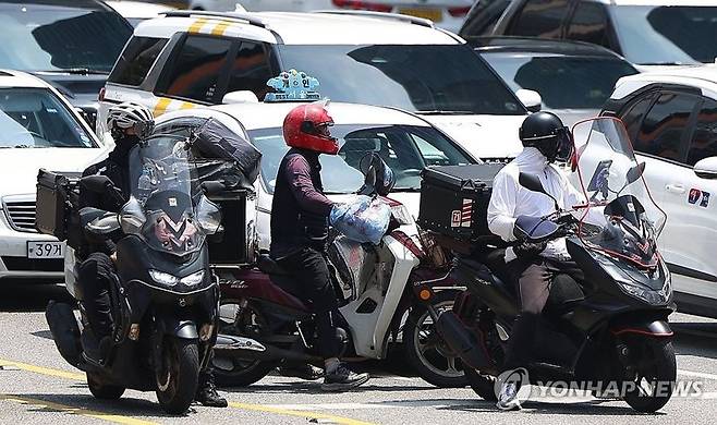 서울 강남역 사거리에서 배달라이더들이 교통신호를 기다리고 있다