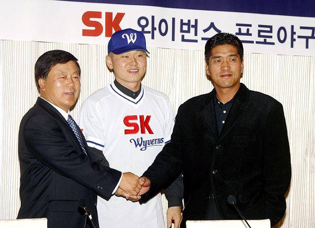 2002년 12월 자유계약선수(FA)로 SK 와이번스와 계약한 박경완(가운데)이 입단식에서 조범현(오른쪽) 감독, 안용태(왼쪽) 사장과 손잡고 포즈를 취하고 있다. 필자 제공