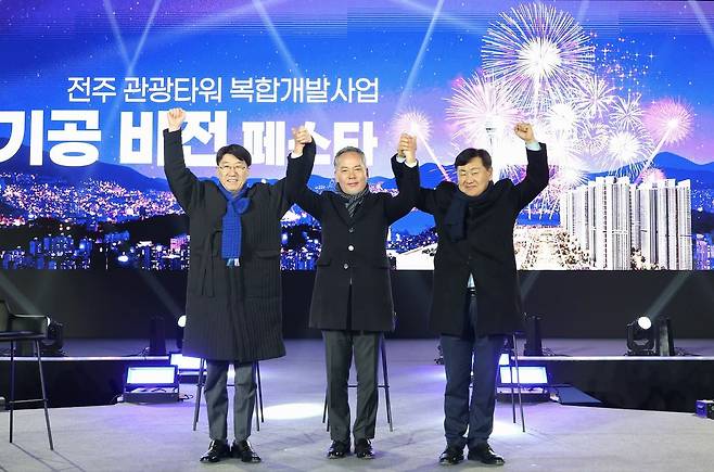 지난 11일 전북 전주시 효자동 옛 대한방직 부지에서 열린 '전주 관광타워 복합개발사업 기공 기념 비전 페스타'에서 시행사인 ㈜자광 전은수 회장(가운데)이 김관영 전북지사(오른쪽)와 우범기 전주시장과 맞잡은 양손을 번쩍 들어 올리고 있다. [사진 우범기 전주시장 페이스북 캡처]