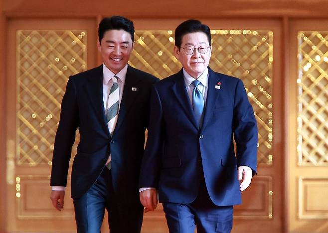 이재명 대통령과 강훈식 청와대 비서실장이 1월 15일 청와대 세종홀에서 열리는 수석·보좌관 회의에 입장하기 위해 이동하고 있다. 강 비서실장은 충남지사 출마설이 제기된다. [사진 청와대사진기자단]