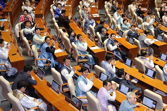 한복을 입은 더불어민주당 의원들이 지난 12일 서울 여의도 국회에서 열린 제432회국회(임시회) 제7차 본회의에서 방청객들을 향해 인사하고 있다. 뉴스1