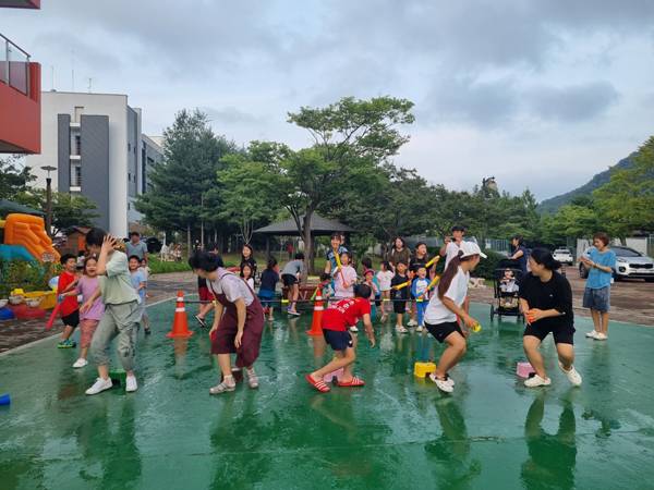 부모와 아이들이 여름 물놀이를 즐기는 모습. / 의령꿈나르미육아센터