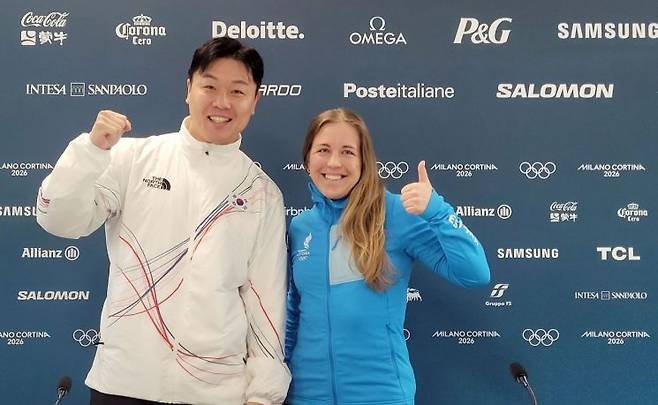 원윤종이 19일 이탈리아 밀라노의 2026 밀라노·코르티나 동계올림픽 선수촌에서 IOC 선수위원 투표 결과 당선을 확인한 뒤 선수위원에 함께 당선된 에스토니아의 바이애슬론 선수 요한나 탈리해름과 기념사진을 찍고 있다.   [사진 제공= 연합뉴스]