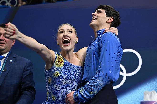 12일 밀라노 코르티나 동게올림픽 피겨스케이팅 아이스댄스에서 동메달을 딴 파이퍼 길레스(왼쪽)와 폴 포리에이가 점수를 확인하고 기뻐하고 있다. 난소암을 이겨낸 길레스는 빈센트 반 고흐의 명화 ‘별이 빛나는 밤’을 의상에 새기고, 뇌종양으로 먼저 세상을 떠난 어머니가 좋아했던 노래 ‘빈센트’에 맞춰 열연을 펼쳤다./AFP 연합뉴스
