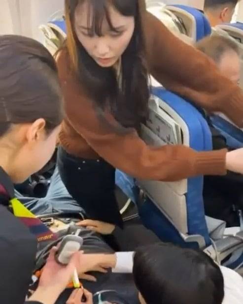 지난 10일 오후 울산대병원 6년차 간호사 이소영(31)씨가 울산공항에서 이륙 중이던 항공기 기내에서 경련을 일으킨 남성 승객을 살펴보고 있다. 이씨의 빠른 대처로 이 승객은 호흡을 되찾고 인근 병원으로 옮겨져 치료를 받았다. 사진은 당시 상황을 찍은 영상 캡처./울산대병원