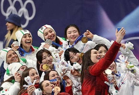 18일(현지시간) 이탈리아 밀라노 아이스스케이팅 아레나에서 열린 2026 밀라노-코르티나담페초 동계올림픽 쇼트트랙 여자 3000m 계주에서 금메달을 따낸 한국대표팀 선수들이 은메달을 따낸 이탈리아 선수, 동메달을 따낸 캐나다 선수들과 셀카를 찍고 있다. [사진=연합뉴스]