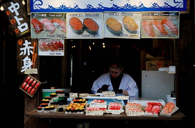 지난 16일 일본 도쿄의 한 시장에서 초밥 롤을 판매하는 매장의 상인이 일하고 있다. (사진=로이터)
