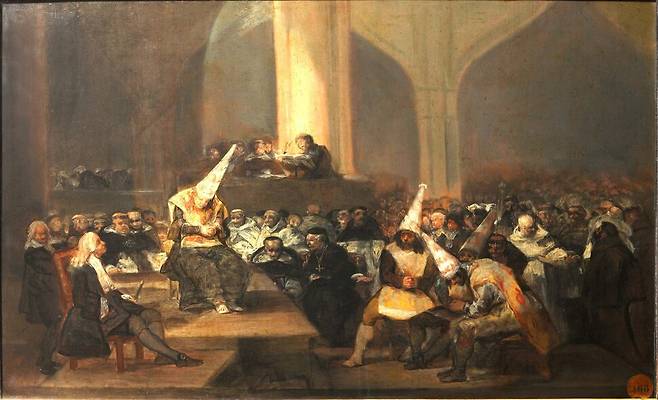 프란시스코 데 고야(1746~1828)가 그린 ‘종교재판소’. 스페인 종교재판의 잔혹성과 위선을 고발한 이 작품에서 이단자로 낙인찍힌 이들이 뾰족한 모자를 쓰고 심문받고 있다. 재판관과 군중은 침묵 속에서 그 광경을 지켜보고 있다. 고야는 어두운 색조와 강한 명암 대비를 통해 종교적 광신과 권력의 폭력을 비판했는데, 이를 통해 신앙이 권위의 도구로 타락한 현실을 고발하는 동시에 인간의 자유와 양심을 옹호했다. 길 제공, 위키미디어 코먼스