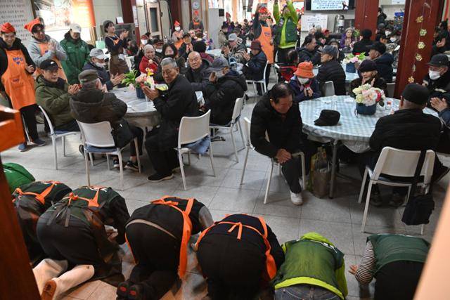 다일공동체 대표 최일도 목사를 비롯한 밥퍼나눔운동본부 직원들이 14일 서울 동대문구 밥퍼나눔운동본부를 찾은 어르신들을 위해 배식에 앞서 큰절을 하고 있다. 류효진 선임기자