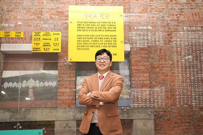 김춘성 조선대 총장이 지난 11일 광주광역시 동구 조선대 본관 1층에서 민립대 건립 당시 성금을 낸 시민들의 이름이 적힌 ‘명예의 전당’ 앞에서 개교 80주년을 맞는 조선대의 글로컬대 도약 방안을 설명하고 있다. [사진 조선대]